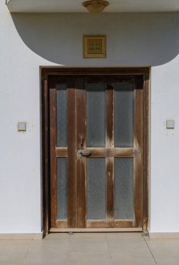 Cam panelli yıpranmış ahşap bir kapı, binanın tuhaf atmosferini geliştirmek için sıcaklığı davet ediyor..