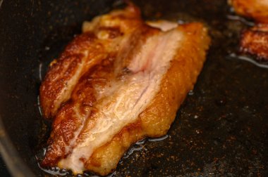 Ağız sulandıran pastırma tavada kızarır, aydınlık bir sabahta mutfağı lezzetli bir aromayla doldurur..