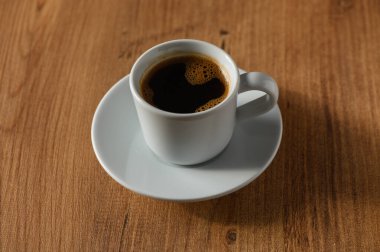 Taze demlenmiş kahvenin sıcaklığının tadını çıkar. Basit beyaz bir fincanda, huzuru ve tefekküre davet ediyor..