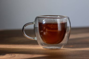 Taze demlenmiş çayın rahatlatıcı aroması güneş ışığı cam bardakta dans ederken havayı doldurur..