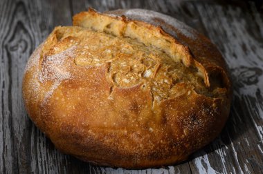 Altın sarısı yuvarlak somun ekmek vitrinleri güzel çatlamış bir kabuk sıcak öğleden sonra ışığında doğal özellikler.