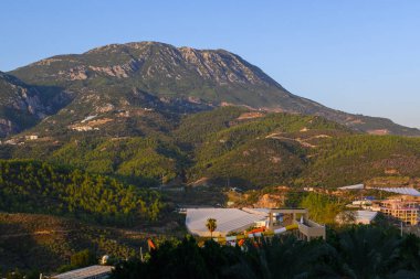 Şafağın altın ışıkları, dağlara ve vadilere sıcak bir ışık saçıyor, nefes kesici bir sabah manzarası yaratıyor..