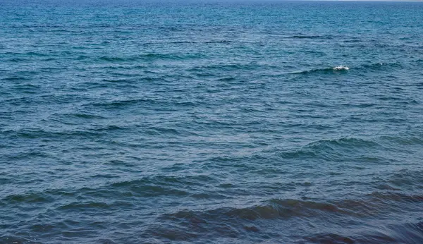 Huzurlu okyanus dalgaları sessizce dalgalanır, huzurlu bir kıyı öğleden sonranın huzurlu özünü yakalar..