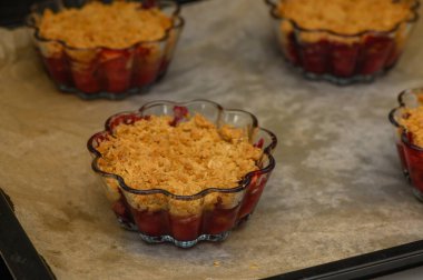 Bireysel kaseler sıcak kiraz parçacıkları fırında güneşleniyor, altın tepsileri tatlı hoşgörüyü davet ediyor..