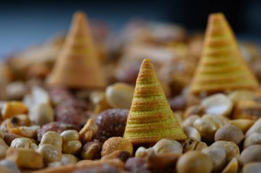 Küçük, koni biçimli atıştırmalıkların eğlenceli bir düzenleme çeşitli fındıklar arasında oturur, neşeli bir kutlamada neşeli bir atıştırmalık masasına renk ve kapris bir pop ekler.