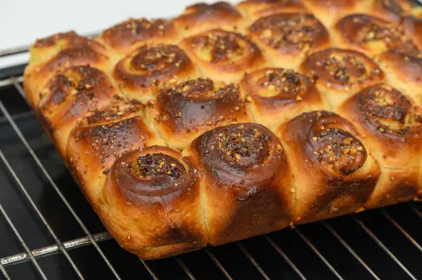 Fırından yeni fırınlanmış ekmekler, üzerinde çıtır çıtır, aromalı bir katman bulunan altın bir kabuk sergiliyor. Bu enfes yaratılış herkesi sıcaklığının ve aromasının tadını çıkarmaya davet ediyor..