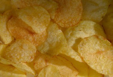 Mükemmel kızarmış patates cipslerinden oluşan cezbedici bir karışım çerçeveyi altın renkleri ve pürüzlü dokularıyla doldurur ve herkesi hoş bir atıştırma molasına davet eder..