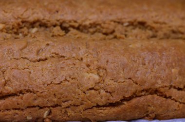 Sıcak bir somun taze pişmiş ekmek tezgahın üzerinde duruyor, altın kabuğunu ve davetkar dokusunu sergiliyor..