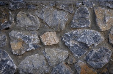 Yakından bakınca, doğal taşların karmaşık düzenini ortaya koyuyor, çeşitli doku ve renkler sergiliyor..