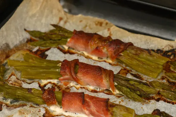 Çıtır prosciutto ile kaplanmış taze kuşkonmaz sapları leziz bir lezzet ve doku kombinasyonu sunar..