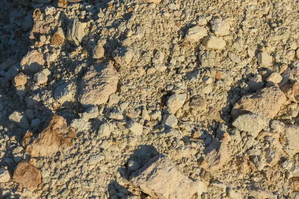 Toprak, toprak, kaya ve çakıl taşlarından oluşan bir duvar halısını gün ışığına çıkarır..