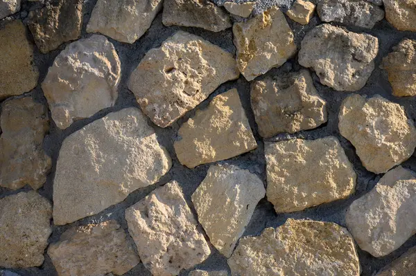 Yıpranmış taşlar, doğayı ve işçiliği harmanlayan parlak bir zemin üzerine toprak dokusunu sunar..