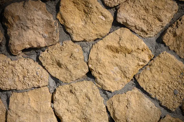 Sıcak renkli taşlar, doğanın güzelliğini ve işçiliğini gösteren, dokulu bir düzende birbirine kenetlenir..