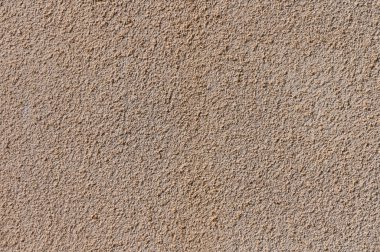 Sert, kumlu bir yüzey, gün ortası ışıltısı altında toprak tonları ve karmaşık desenler sergiliyor..