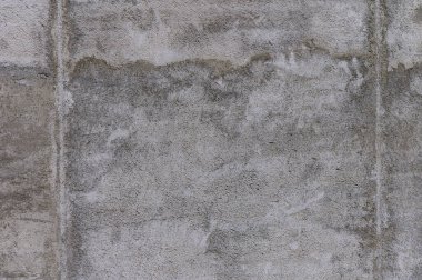 Yaşlanan beton bir duvarın yüzeyi, zamanın ve giysinin hikayesini anlatan kumaş ve gölgelerin bir karışımını sergiler..