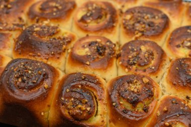 Sıcak, aromatik tarçın ruloları fırından çıkar, altın kabukları tatlı bir jöleyle parlar ve üzerine fındık serpiştirilir. Nefis bir sabah ziyafeti bekliyor.