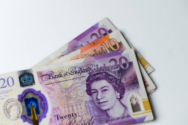 Parlak, renkli banknotlar temiz, beyaz bir yüzey üzerine serilmiş, günlük işlemler ve ticarette para biriminin değerini temsil eden karmaşık tasarım ve özellikleri gözler önüne seriliyor..