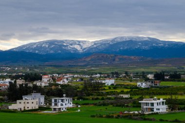 Huzurlu tarım arazileri ve tuhaf konutların üzerinde kar kulesiyle kaplı görkemli dağlar karamsar gökyüzüne karşı çarpıcı bir kontrastlık yaratıyor. Doğa ve mimari bir arada güzel bir şekilde yaşıyor..