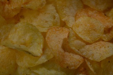 Çeşitli kıtır kıtır, altın patates cipsleri kaseyi doldurarak, abur cubur meraklılarını şımartmaya davet ediyor. Öğleden sonra güneşi sıcacık bir ışıltı saçar, bu gevrek ziyafetin rengini ve cazibesini arttırır..