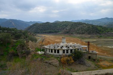 Bir zamanlar hareketli bir alandı, çürüyen bina kavrulmuş toprak ve kayan tepelerin, kasvetli bir gökyüzünün altında çarpıcı bir manzaraya karşı duruyordu. Doğa kendi alanını geri almaya başlar..