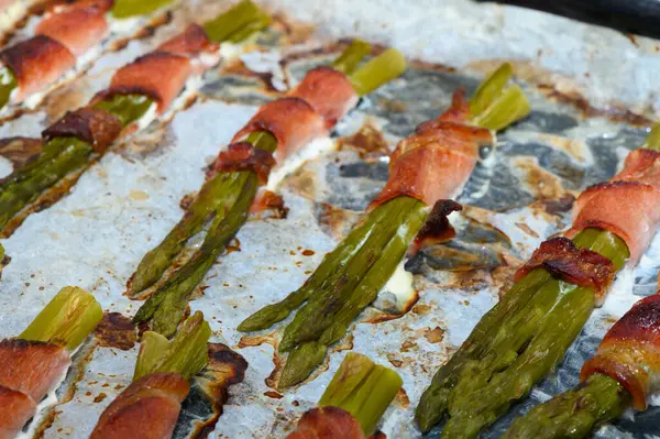 Taze kuşkonmaz mızrakları çıtır çıtır pastırma ile güzelce sarılır. Pişirme tepsisinde lezzet katar. Bu barbekü zevki açık hava toplantıları için mükemmel. Tadı ve lezzeti harmanlamak için..