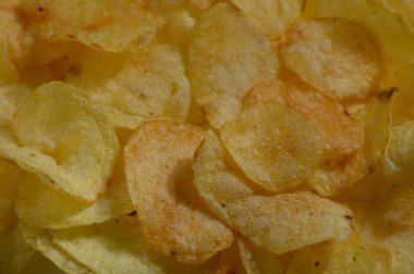 Lezzetli bir patates cipsi çeşidi, lezzetli bir altın rengi sergiliyor, sıradan bir toplantı sırasında paylaşmak için mükemmel ya da evde dinlenirken tek başına eğlenmek için..