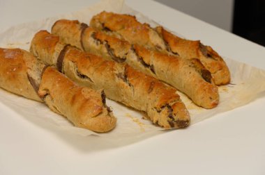 Parşömen kağıdının üzerinde içi çikolata dolu lezzetli pastalar, altın kabuklarını ve davetkar aromalarını sergiliyorlar, sıcak bir öğleden sonra ziyafeti için mükemmel.