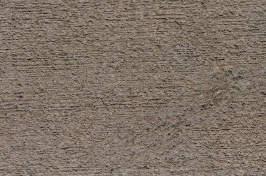Zamanla oluşmuş eşsiz doku ve desenleri gösteren eskimiş beton kaplamalara yakın çekim. Güneş ışığı, ışığın ve gölgenin sanatsal etkileşimini yaratan ince varyasyonları vurgular.