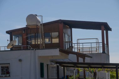 Geniş pencereli, uydu antenli ve canlı bir gökyüzüne karşı kurulmuş eşsiz bir mimari tasarımı olan çatı katı. Bu alan estetik ve yararlılığı birleştirir.