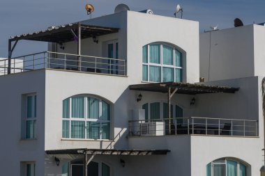 Çağdaş mimari çeşitli balkonları olan beyaz binalar tasarlayarak sakinlerin güneşlenirken kıyı manzarasının keyfini çıkarmalarını sağlıyor..