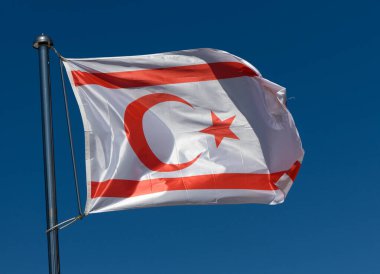 Kuzey Kıbrıs 'ın bayrağı canlı bir şekilde, ulusal gururu simgeleyen sakin mavi bir zemin üzerinde dalgalanıyor. Tasarım hilal ay ve yıldızı yansıtıyor, dikkat çekiyor..