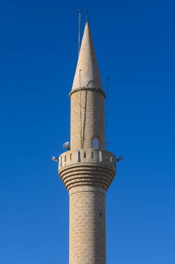 Çarpıcı bir minare zarif bir şekilde yükseliyor, karmaşık taş işçiliği ve yüksek bir kule sergiliyor. Canlı bir kasabada, parlak mavi gökyüzünün altındaki zengin kültürel mirasın bir kanıtı olarak duruyor..
