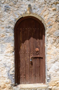 Kuzey Kıbrıs 'taki bir ortaçağ kalesi olan St. Hilarion Kalesi' nin antik ahşap kapılarına yakın çekim. Aşınmış kapılar ve yıpranmış dokuları uzun tarihi ve mimariyi gözler önüne seriyor.