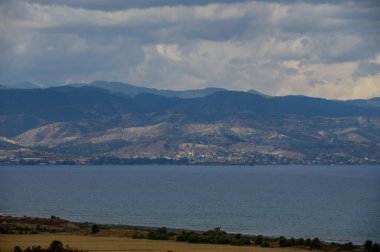 Açık mavi gökyüzünün altında kayalık dağlar ve turkuaz denizle Kıbrıs 'ın nefes kesici kıyı şeridi manzarası. Mükemmel bir yaz seyahati..