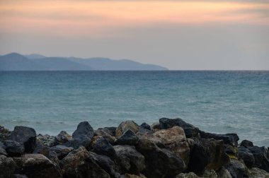 Kıbrıs 'ta deniz ve dağlarla Akdeniz gün batımı manzarası