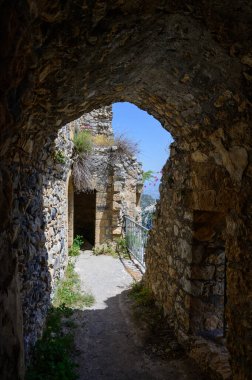 Kalenin içindeki taş çerçeveli pencere dağ manzarası sunuyor. Tarihi atmosfer ve eski mimari.