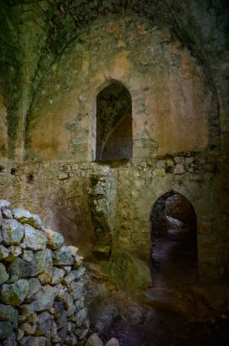 Kuzey Kıbrıs 'taki antik kale tasarımını yansıtan ortaçağ kemerleri ve dokulu duvarlarıyla Saint Hilarion Kalesi' nin içindeki dar taş koridor..