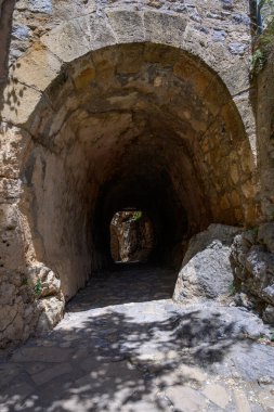 Kuzey Kıbrıs 'taki ortaçağ St. Hilarion Şatosu' ndaki dar taş koridor. Antik duvarlar ve kemerler gizemli tarihi bir atmosfer yaratır..