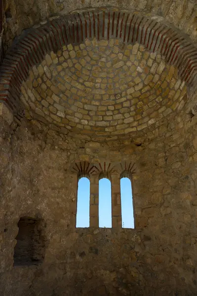 St. Hilarion Kalesi 'nde tarihi bir oda kemerli taş bir tavan ve manzaralı güzel bir üçlü kemerli pencere..