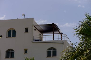Kıbrıs 'ta Akdeniz yakınlarındaki modern beyaz villalar. Parlak mimari, güneşli bir gün ve mavi gökyüzü barışçıl bir kıyı atmosferi yaratır..