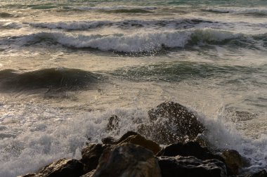 Kıbrıs kıyısı yakınlarında dokulu deniz suyu ve kırılan küçük dalgaların yakın görüntüsü. Akdeniz çevresindeki doğal deniz ayrıntıları.
