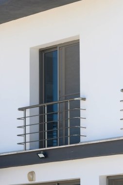 Çağdaş bir balkon şık korkulukları ve temiz çizgileri ile bekliyor, parlayan beyaz duvarların arkaplanına çerçevelenmiş, sükuneti ve sofistike havayı davet eden.