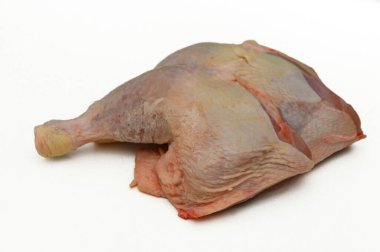 Parlak ışıklandırılmış mutfak tezgahında çiğ tavuk kesiği var. Yumuşak yüzeyini ve organik görünümünü vurguluyor. Lezzetli bir yemeğin parçası olarak baharat ve pişirmeye hazır..