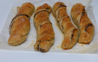 Altın kahverengi ekmek çubukları mükemmel pişirilir, çıtır çıtır bir dış görünüş ve enfes bir dolgu sergilerler. Bu ev yapımı yaratılış sıcaklığı ve rahatlığı yayıyor, herkesi tadıma davet ediyor..