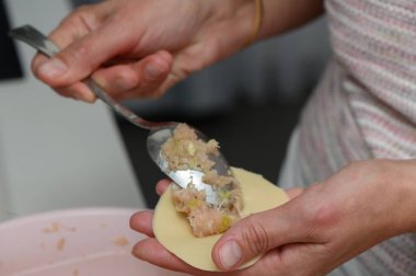 Eller, hamur çemberlerini sıcak ve davetkar bir mutfakta lezzetli malzemelerle doldurarak ustalıkla yemek pişirme zevkini hazırlar. Arkadaşlar yemek pişirmek için toplanırken kahkaha ve sohbet havayı dolduruyor..