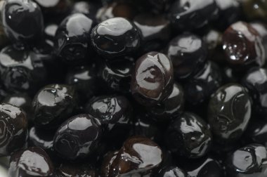 Çerçeveyi, pürüzsüz yüzeyleri ve doğal parıltılarıyla donatan parlak siyah tohum koleksiyonu doldurur. Yumuşak parıltı, onların karmaşık şekillerine ve kalıplarına dikkat çeker..