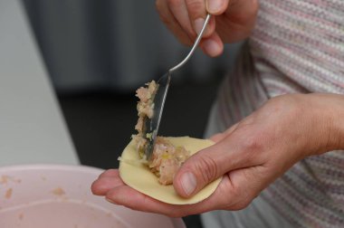 Eller bir hamur köftesini ustalıkla şekillendirir, lezzetli bir karışım ile doldurur. Mutfağın sıcak havası, tatların bir araya gelip akşam yemeğinin lezzetini arttırır..