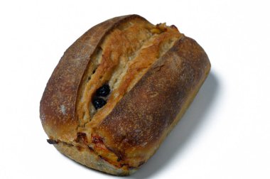 Sıcak bir zanaatkar somunu beyaz bir yüzeye davetkar bir şekilde uzanır. Kabuklu dış görünüşü benzersiz bir şekli ortaya çıkarır. Kırsal zarafet, geleneksel pişirme sanatını en iyi şekilde sergileyerek parlıyor..