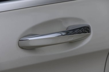 Bir arabanın parlak krom kapı kolu çevre ışığını yansıtır, parlak hatlarını ve modern estetiğini ön plana çıkarır. Ayar, çağdaş otomotiv tasarımı ve işlevinin özünü yakalar.