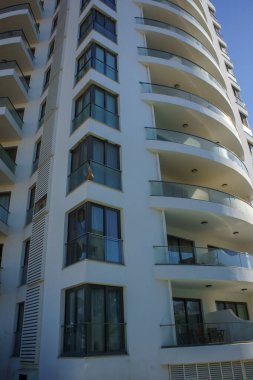 Çarpıcı bir konut yapısı kıvrımlı balkonlar ve çağdaş tasarım sergiliyor. Güneş ışığını çok güzel yansıtıyor..